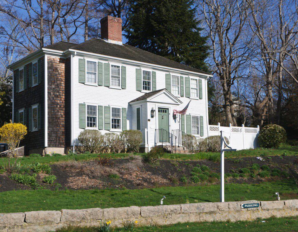 White colonial house with green shutters.