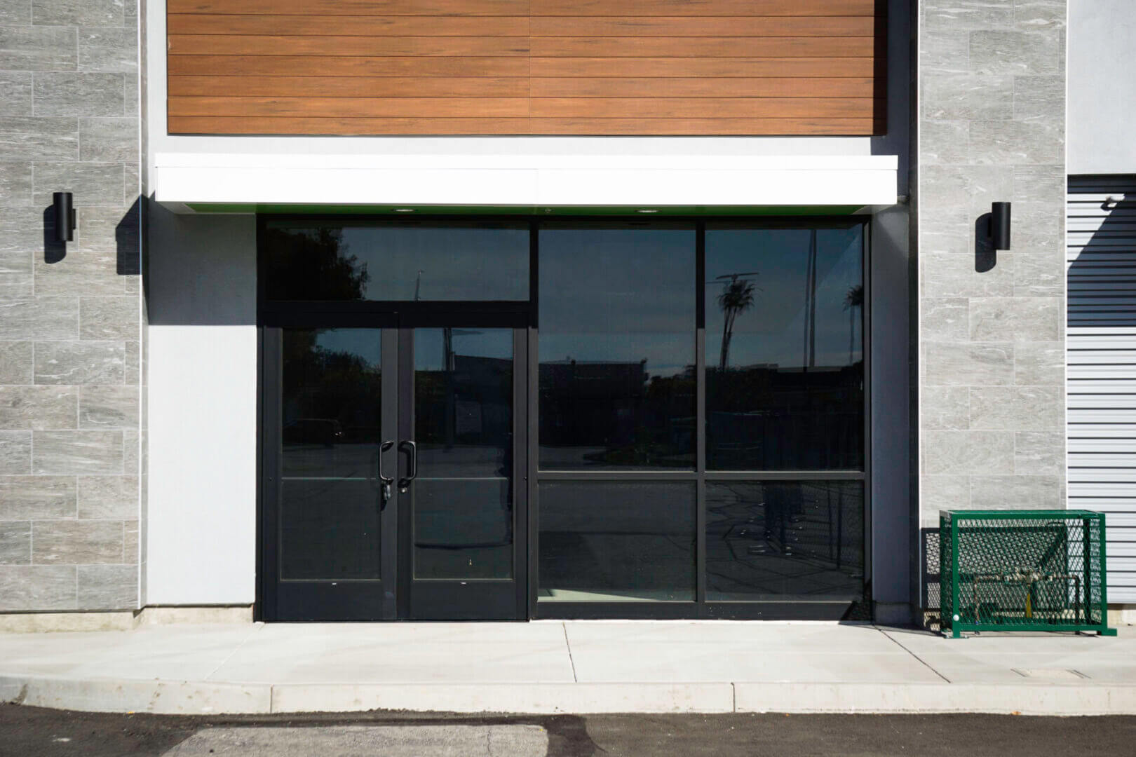 Closed storefront with large black glass windows and double doors.