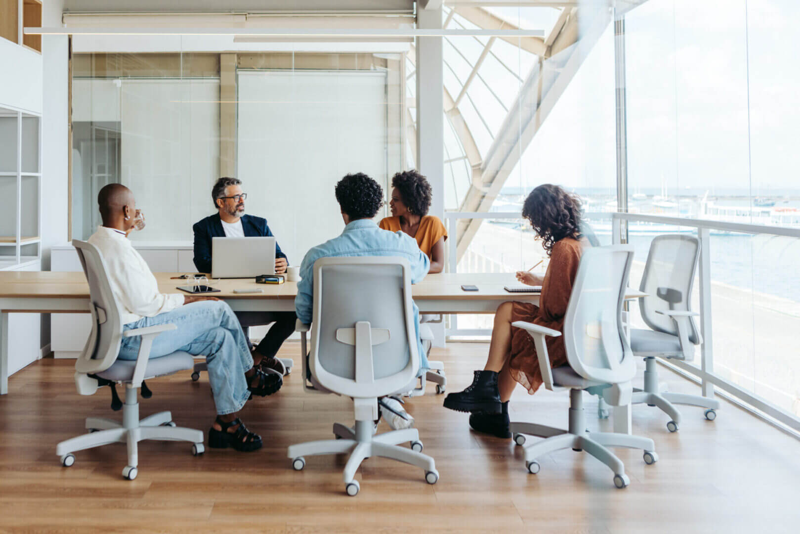 A group of professionals in a meeting room discussing work.