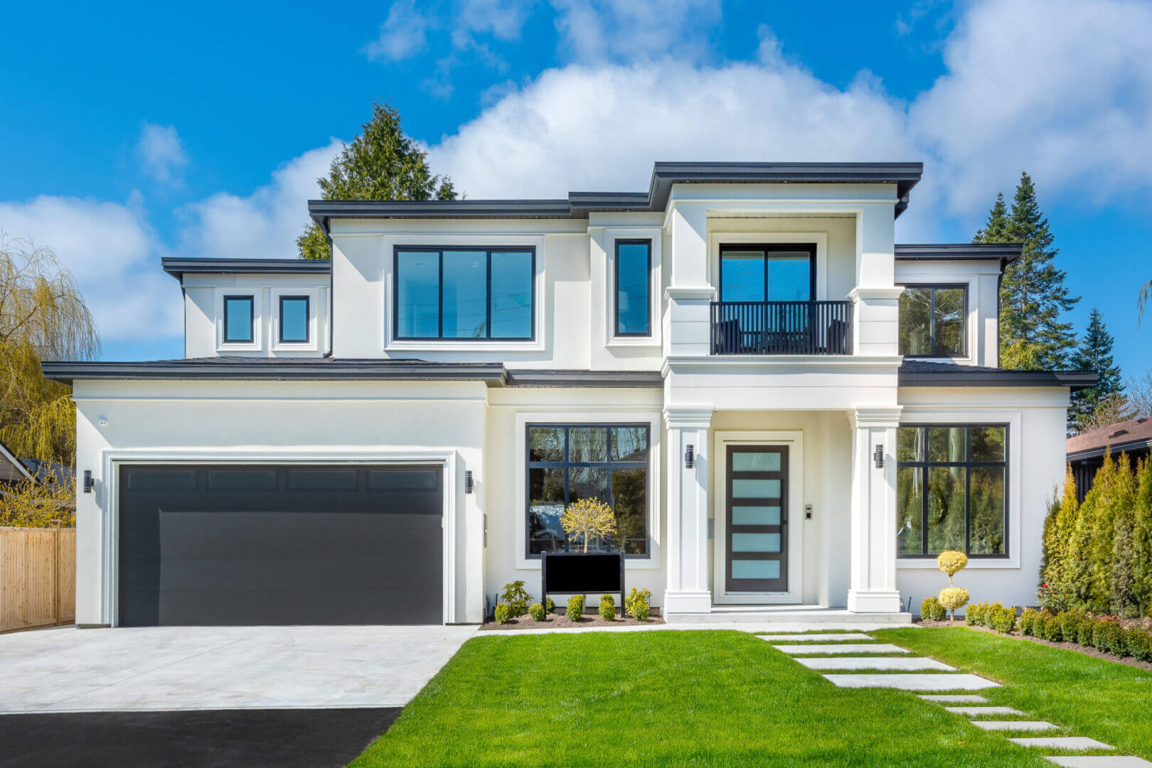 Modern two-story house with large windows and a spacious garage.