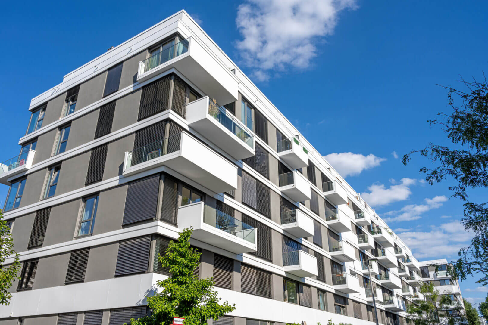 Modern apartment building under a bright blue sky.